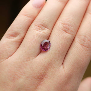 Oval shaped pink spinel on hand