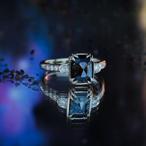 Rectangular cut black diamond ring in blue and purple light with reflections quarter view