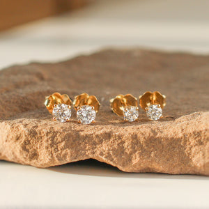Round Diamond Stud Earrings in group on stone