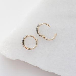 Blue Sapphire Gold Hoops open side view on white marble 