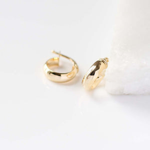 Domed Chunky Hoops in yellow gold detail view on marble 