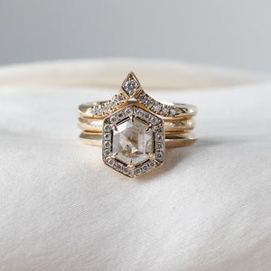 V Shaped Diamond Point Band stacked with large diamond ring and a large golden band  on fabric