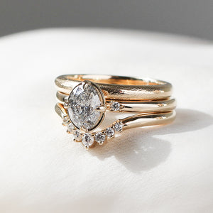 Oval Brilliant cut diamond ring paired with 2 diamond and gold stacking bands detail quarter view