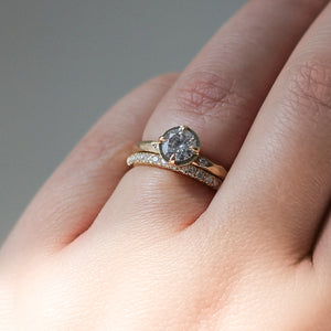 Round Brilliant cut diamond ring paired with diamond gold stacking band on hand in sunlight