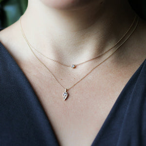 Tear Drop Diamond Sun Necklace paired with a dimond necklace being worn 
