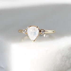 Pear icy diamond ring in sunlight on marble