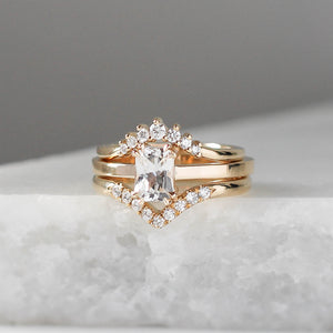 White Sapphire Gold Ring paired with 2 diamond  stacking bands on marble 