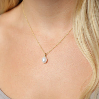 Pearl necklace on gold chain worn on neck