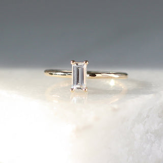 White sapphire ring stacker in yellow gold on marble detail front view