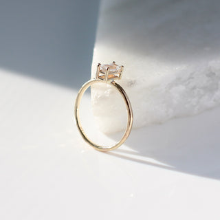 White sapphire ring stacker on marble profile view in sunlight