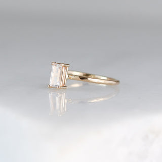 White sapphire ring stacker side view on marble with reflections 