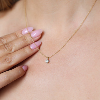 Round Lab Diamond Necklace in yellow gold being worn, partially draped over hand with pink nails