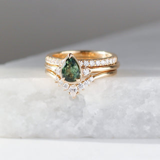  Pear Cut Green Sapphire ring stacked with diamond godl band and diamond crown band on marble
