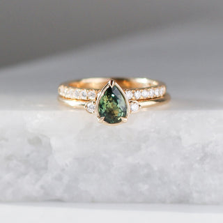  Pear Cut Green Sapphire ring stacked with diamond gold band on marble