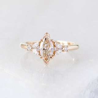 Yellow gold ring with a champagne marquise cut diamond and white diamond clusters, front view