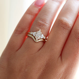 Yellow gold ring with a champagne marquise cut diamond and white diamond clusters stacked with pointed wedding band, on hand