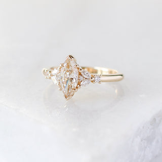 Yellow gold ring with a champagne marquise cut diamond and white diamond clusters, quarter view