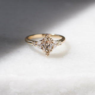 Yellow gold ring with a champagne marquise cut diamond and white diamond clusters, front view