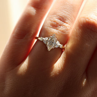 Yellow gold ring with a champagne marquise cut diamond and white diamond clusters, on hand