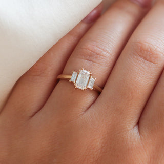 Emerald cut champagne diamond ring with baguette side stones in yellow gold, on hand