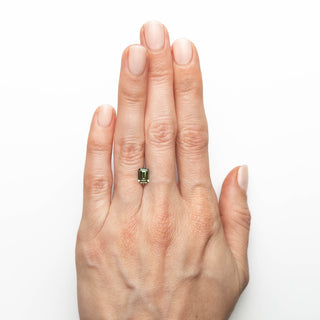 Green emerald cut sapphire on hand