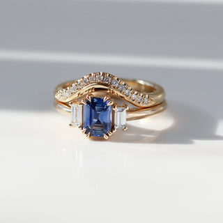  Emerald Cut Blue Sapphire Ring paired with diamond wave band in sunlight front view