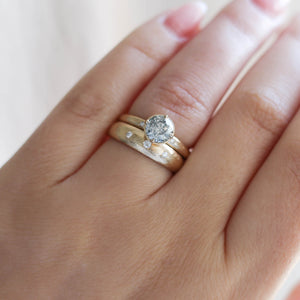 Round salt and pepper diamond ring with wedding band on hand