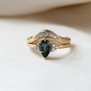 Pear Teal Green Sapphire Ring stacked with diamond gold band on fabric quarter front view