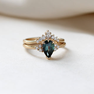 Pear Teal Green Sapphire Ring stacked with crown diamond gold band on fabric  quarter front view 
