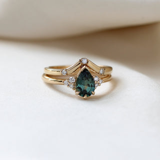 Pear Teal Green Sapphire Ring stacked with 3 point diamond gold band on fabric quarter front view