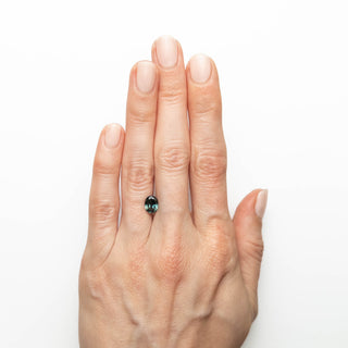 Teal oval brilliant cut sapphire on hand