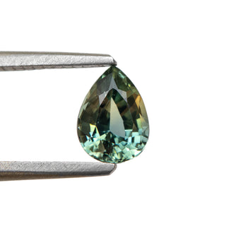 Teal pear cut sapphire in tongs