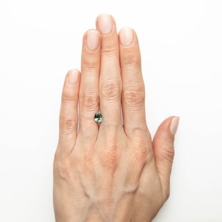 Teal pear cut sapphire on hand
