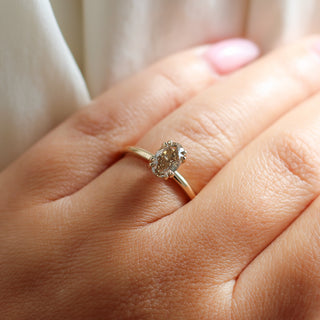 Yellow gold solitaire engagement ring with an oval champagne diamond, on hand