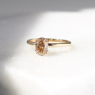 Yellow gold solitaire engagement ring with an oval champagne diamond, quarter view