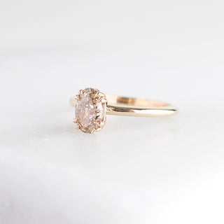 Yellow gold solitaire engagement ring with an oval champagne diamond, quarter view