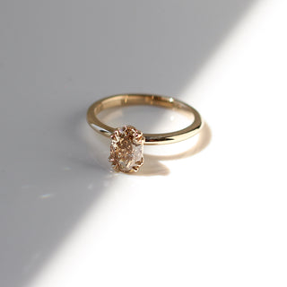 Yellow gold solitaire engagement ring with an oval champagne diamond, front view from above
