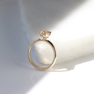Yellow gold solitaire engagement ring with an oval champagne diamond, side view