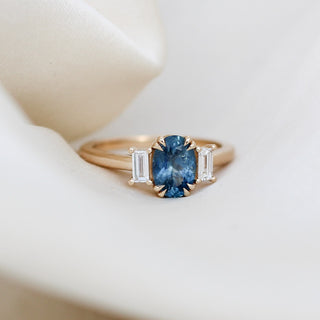Oval cut blue sapphire ring with baguette side stones in yellow gold, front view 