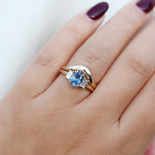 Oval Cut Blue Sapphire Ring with Wave Gold Band worn on hand  