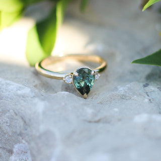 Lagoon Pear Green Sapphire Ring on a stone in sunlight quarter front view
