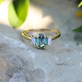 Trilogy Oval Green Sapphire Ring on a stone in sunlight detailed front view  