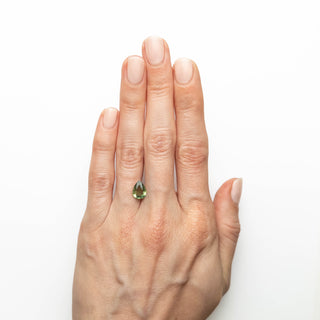Green double cut pear sapphire on hand