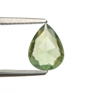 Green double cut pear sapphire in tweezers