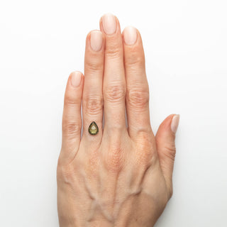 Green double cut pear sapphire on hand
