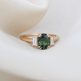 Oval cut green sapphire ring with baguette side stones in yellow gold, front view 