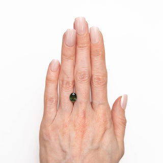 green oval cut sapphire on hand