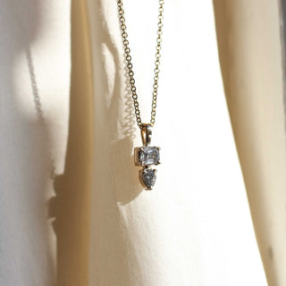 Emerald and pear cut diamond necklace in yellow gold in light front view