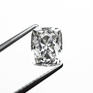 Radiant cut diamond held by tweezers on a white background, ethically sourced and hand-picked by Yuliya Chorna.