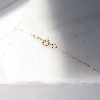 Paper Clip Chain lock in sunlight on marble detailed view